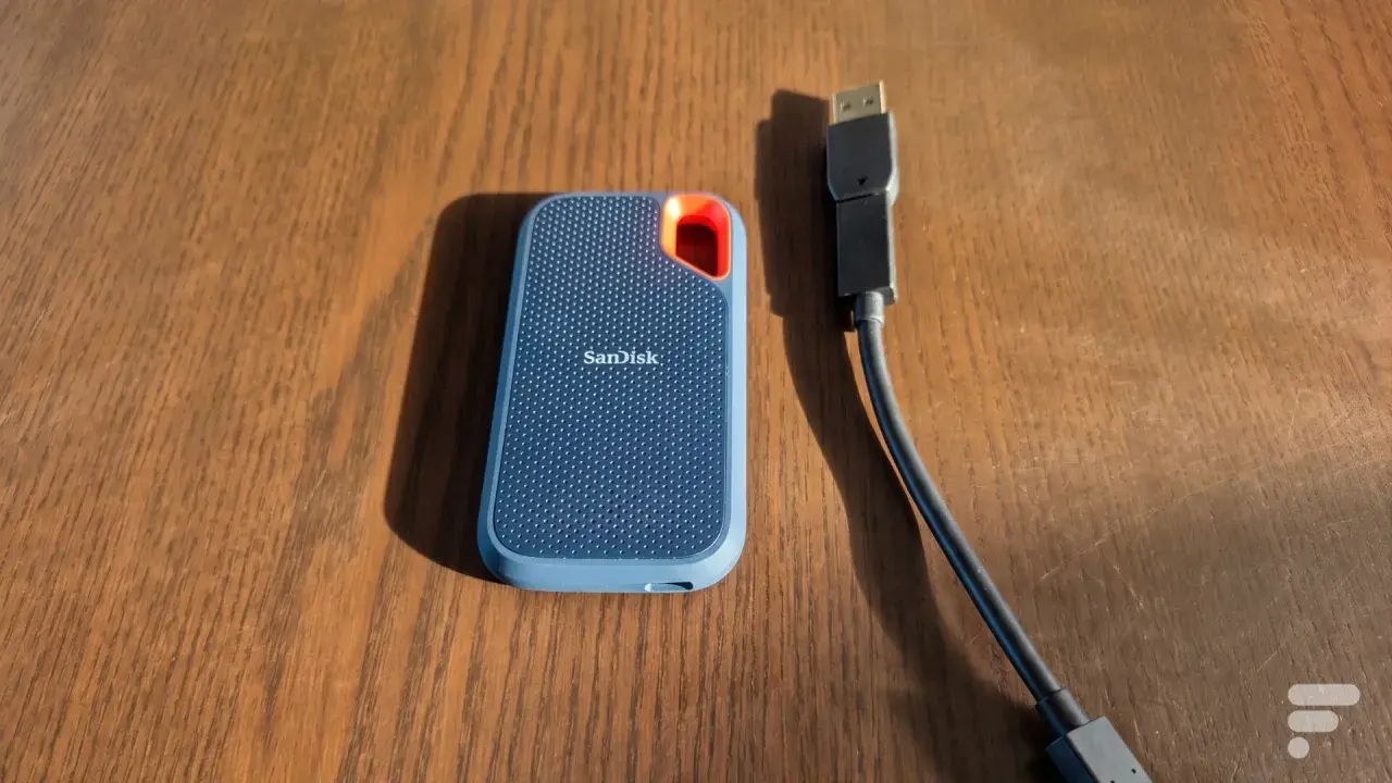 Disque dur externe SanDisk, un SSD portable bleu avec un câble USB.
