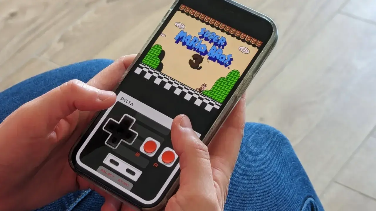 Jouer à Super Mario Bros sur iPhone avec l'émulateur Delta. La manette virtuelle rappelle les consoles d'antan.