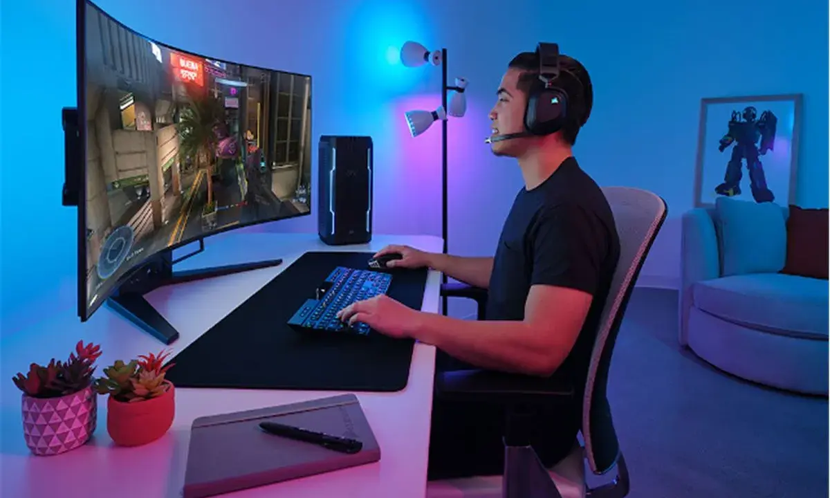 Un joueur concentré sur un écran d'ordinateur incurvé, profitant d'une immersion totale dans son jeu. La taille de l'écran offre une expérience visuelle captivante.