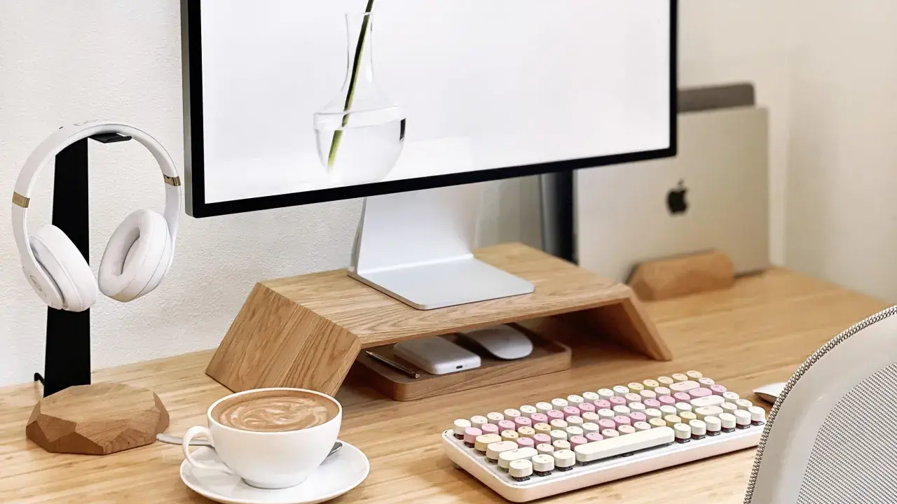 Un café latte, un clavier pastel et un casque blanc composent ce setup bureau idéal pour travailler avec style.