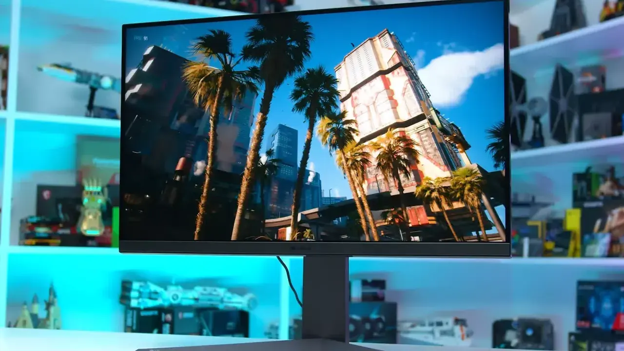 Un écran PC affiche une scène de jeu futuriste avec des palmiers et des gratte-ciel. Le choix de quel écran PC choisir dépend de vos besoins.