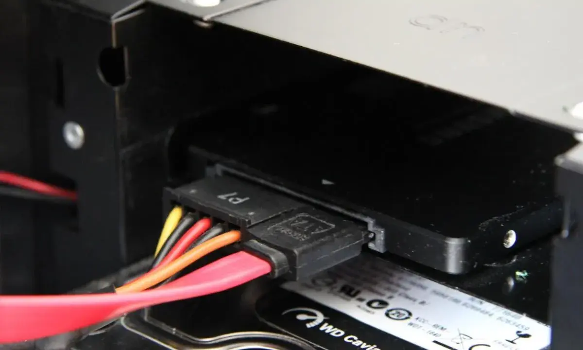 Connexion des câbles SATA pour installer un SSD dans un boîtier d'ordinateur.