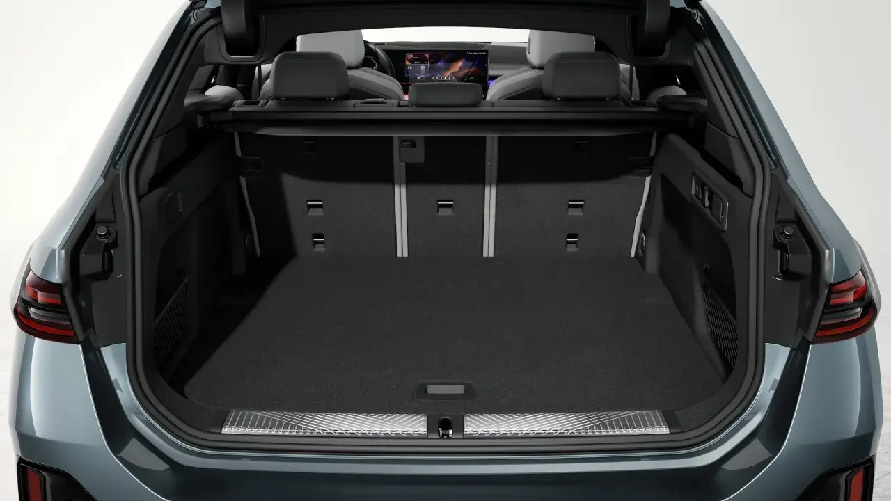 Vue du coffre ouvert d'une Tesla Model Y, montrant son espace de chargement spacieux et les sièges arrière.