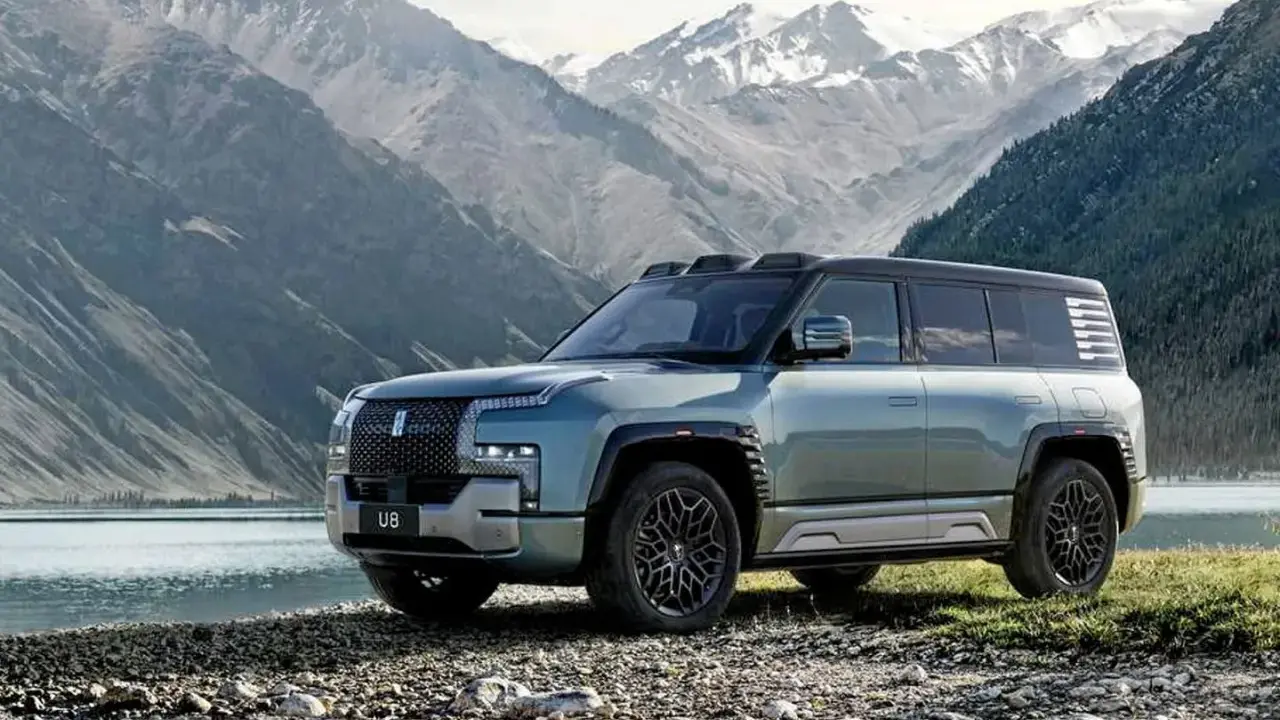 Le byd yangwang u8, un SUV imposant, se tient au bord d'un lac, avec des montagnes enneigées en arrière-plan.