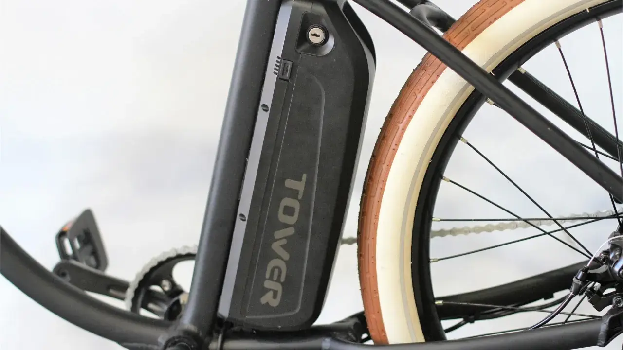 Batterie noire "TOWER" sur un vélo électrique, prête pour son homologation. Pédalier et roue arrière visibles.