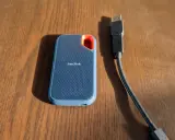 Disque dur externe SanDisk, un SSD portable bleu avec un câble USB.