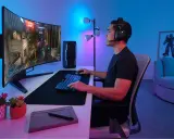 Un joueur concentré sur un écran d'ordinateur incurvé, profitant d'une immersion totale dans son jeu. La taille de l'écran offre une expérience visuelle captivante.