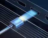 Connexion HDMI pour projeter l'écran de votre PC sur une TV HD. Le câble bleu et or s'insère dans un port, symbolisant le transfert de données.