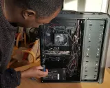 Un homme ajuste l'alimentation d'un PC. Il manipule un tournevis pour le sens alimentation pc.