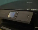 Panneau de contrôle d'une imprimante avec écran, boutons et indicateur Wi-Fi. Une caractéristique imprimante notable est sa connectivité sans fil.