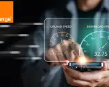 Le logo Orange et un écran affichant les vitesses de téléchargement et d'envoi, avec une Livebox 8 en arrière-plan.