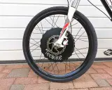 Roue avant d'un vélo électrique TeeBike, prête à être débridée pour plus de puissance. Le moteur est intégré au moyeu.