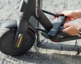 Mains tenant une clé pour comment attacher sa trottinette électrique. Le cadenas est fixé au cadre.