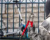 Un voleur, cagoulé et ganté, s'apprête à couper le cadenas d'une trottinette volée avec une pince monstre. Comment retrouver une trottinette volée ?