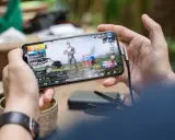 Main d'une personne tenant un smartphone affichant un jeu vidéo, parfait pour les jeux sans connexion.