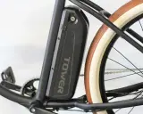 Batterie noire "TOWER" sur un vélo électrique, prête pour son homologation. Pédalier et roue arrière visibles.