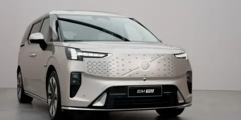 Le **Volvo EM90**, un monospace électrique luxueux, arbore une calandre distinctive et des phares modernes.