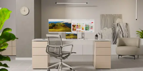 Bureau moderne avec un **écran ergonomique** double, une chaise confortable et une plante verte.