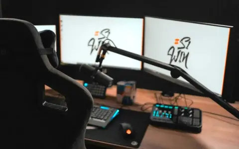 Setup streamer avec fauteuil, deux écrans affichant un logo, micro sur bras articulé, clavier, souris et console de mixage.