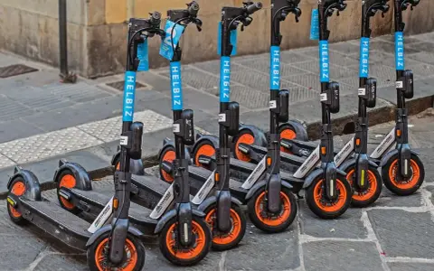 Une rangée de trottinettes électriques Helbiz, prêtes à l'emploi. Imaginez pouvoir debrider trottinette pour une balade urbaine !