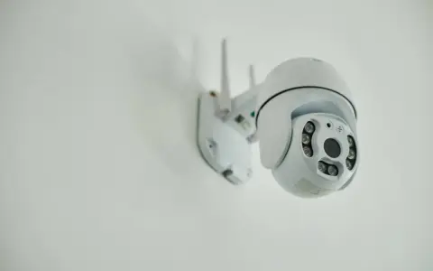 Installation d'une caméra IP blanche sur un mur. Elle est orientable et dotée de plusieurs LED infrarouges.