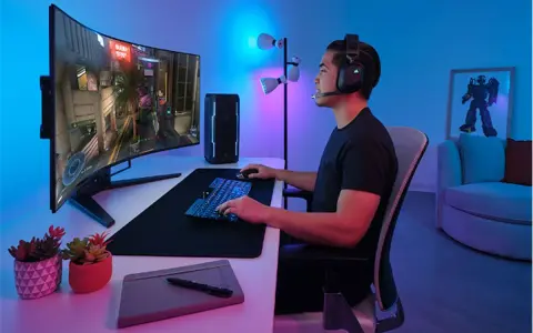 Un joueur concentré sur un écran d'ordinateur incurvé, profitant d'une immersion totale dans son jeu. La taille de l'écran offre une expérience visuelle captivante.