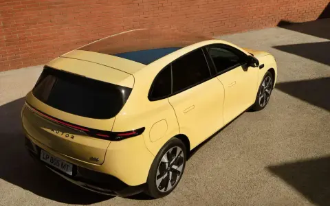 Le Leapmotor B05, un SUV jaune vif, se gare près d'un mur de briques.