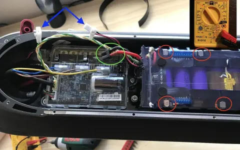 Le fusible de la trottinette électrique est ici, près des connexions de la batterie. Un multimètre est visible.