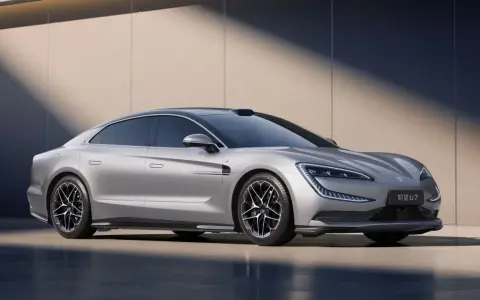 La Yangwang U7, une berline électrique argentée aux lignes futuristes, se dresse fièrement devant un mur texturé.