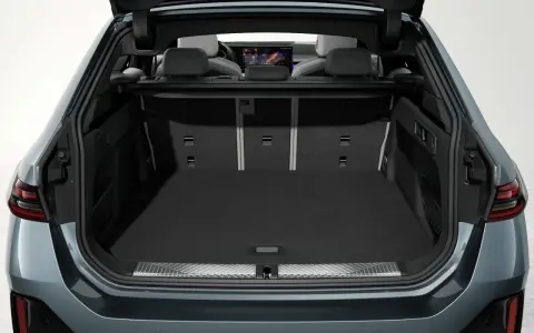 Vue du coffre ouvert d'une Tesla Model Y, montrant son espace de chargement spacieux et les sièges arrière.