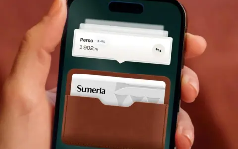 Une main tient un smartphone affichant l'application Sumeria. Une carte bancaire Sumeria est visible dans un étui en cuir marron.