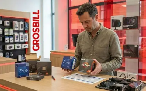 Un homme compare deux boîtes de microprocesseur ordinateur, Intel Core et AMD Ryzen, dans un magasin.