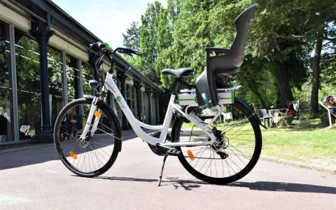 Vélo blanc avec siège enfant, prêt à rouler. Peut-on rouler avec un vélo électrique sans batterie ? Oui, mais ce sera plus difficile !