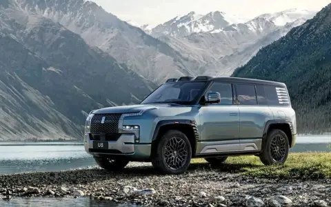 Le byd yangwang u8, un SUV imposant, se tient au bord d'un lac, avec des montagnes enneigées en arrière-plan.