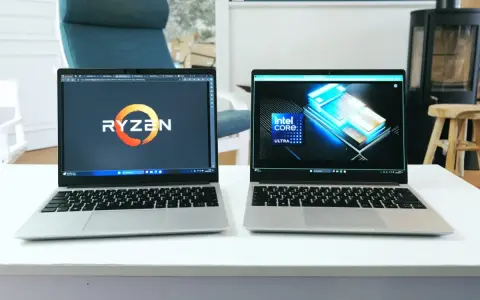 Deux ordinateurs portables côte à côte, l'un affichant le logo Ryzen, l'autre le logo Intel Core Ultra. Un **framework computer** pour chaque processeur.