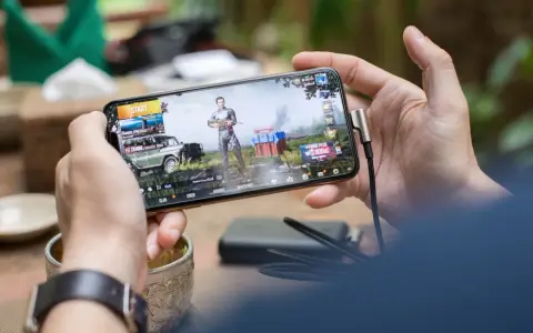 Main d'une personne tenant un smartphone affichant un jeu vidéo, parfait pour les jeux sans connexion.