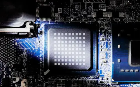 Gros plan sur un processeur d'ordinateur, montrant sa grille de contacts et les circuits imprimés environnants. Le nombre de cœurs du processeur est caché sous cette surface complexe.