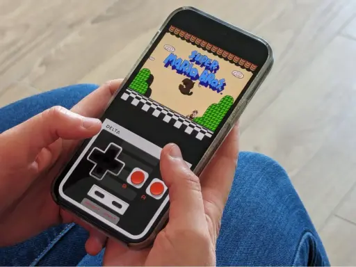 Jouer à Super Mario Bros sur iPhone avec l'émulateur Delta. La manette virtuelle rappelle les consoles d'antan.