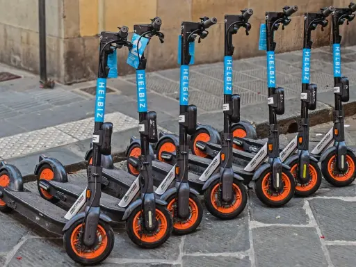 Une rangée de trottinettes électriques Helbiz, prêtes à l'emploi. Imaginez pouvoir debrider trottinette pour une balade urbaine !