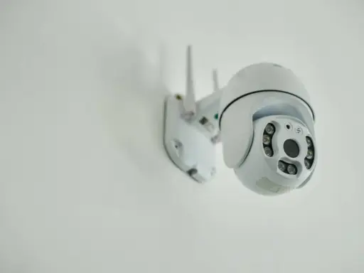 Installation d'une caméra IP blanche sur un mur. Elle est orientable et dotée de plusieurs LED infrarouges.
