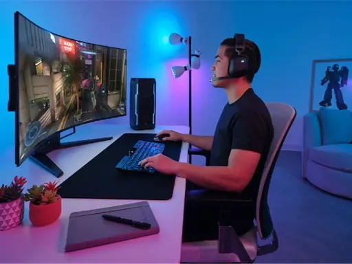Un joueur concentré sur un écran d'ordinateur incurvé, profitant d'une immersion totale dans son jeu. La taille de l'écran offre une expérience visuelle captivante.