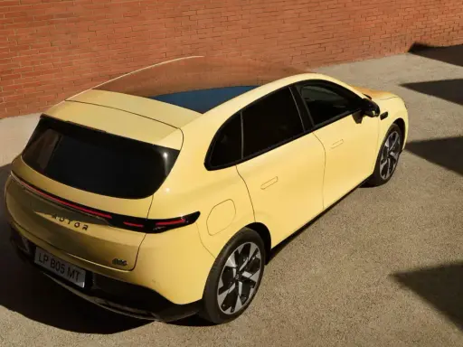Le Leapmotor B05, un SUV jaune vif, se gare près d'un mur de briques.
