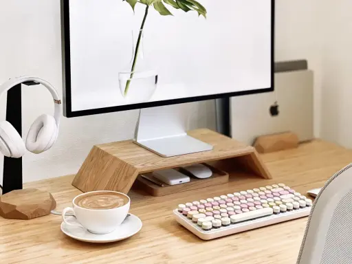 Un café latte, un clavier pastel et un casque blanc composent ce setup bureau idéal pour travailler avec style.