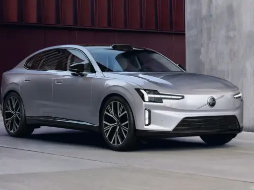 La nouvelle Volvo ES90, une berline électrique argentée aux lignes épurées, se gare devant un bâtiment moderne.