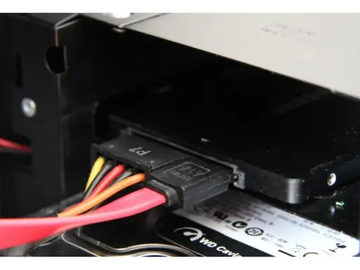 Connexion des câbles SATA pour installer un SSD dans un boîtier d'ordinateur.