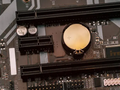 Carte mère MSI avec une pile bouton pour le clear CMOS, des slots PCI Express et des condensateurs.