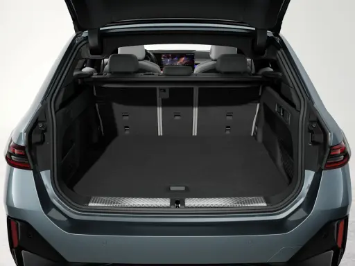 Vue du coffre ouvert d'une Tesla Model Y, montrant son espace de chargement spacieux et les sièges arrière.