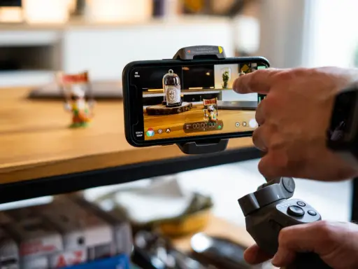 Main tenant, une main utilise un stabilisateur pour un enregistrement camera avec un smartphone.