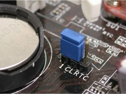 Gros plan sur une carte mère, montrant la pile bouton et le cavalier CLRTC pour réinitialiser le CMOS.