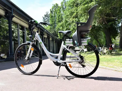 Vélo blanc avec siège enfant, prêt à rouler. Peut-on rouler avec un vélo électrique sans batterie ? Oui, mais ce sera plus difficile !